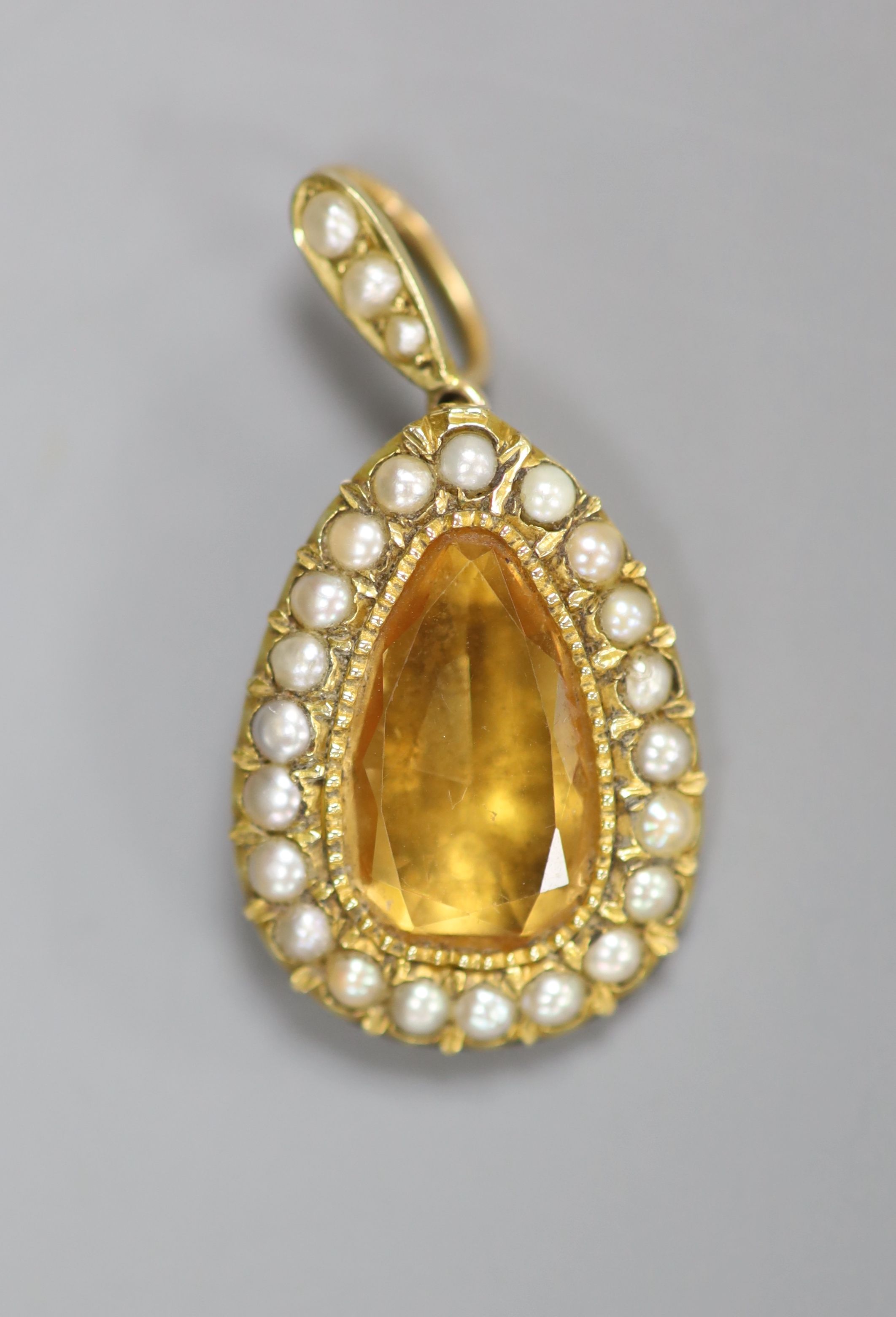 An Edwardian yellow metal, citrine and seed pearl set pear shaped pendant